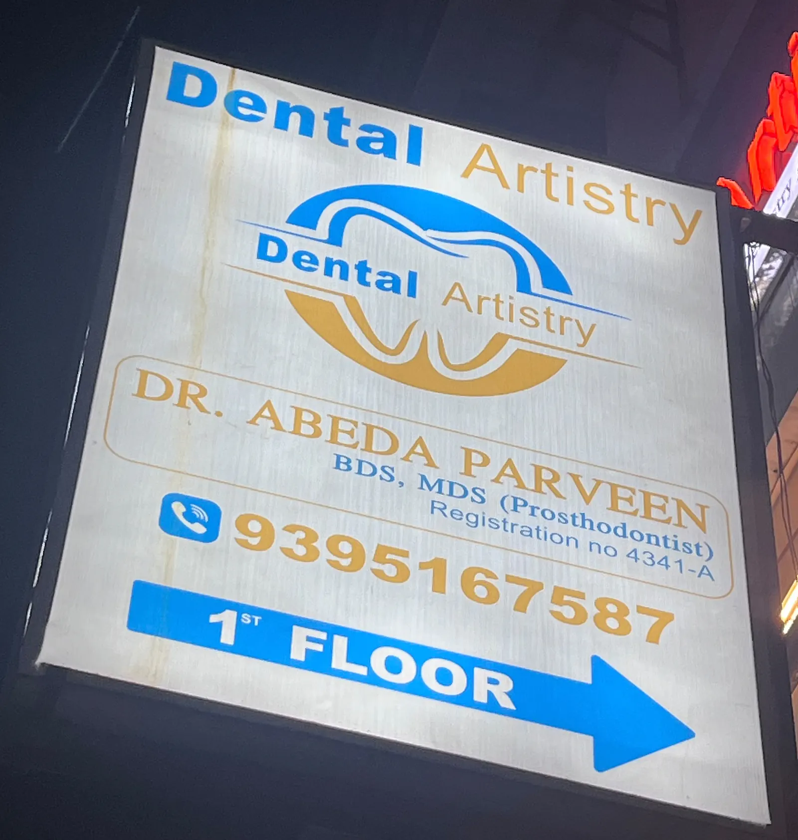 The lit Dental Artistry street sign, naming Dr. Abeda Parveen and pointing to the first floor